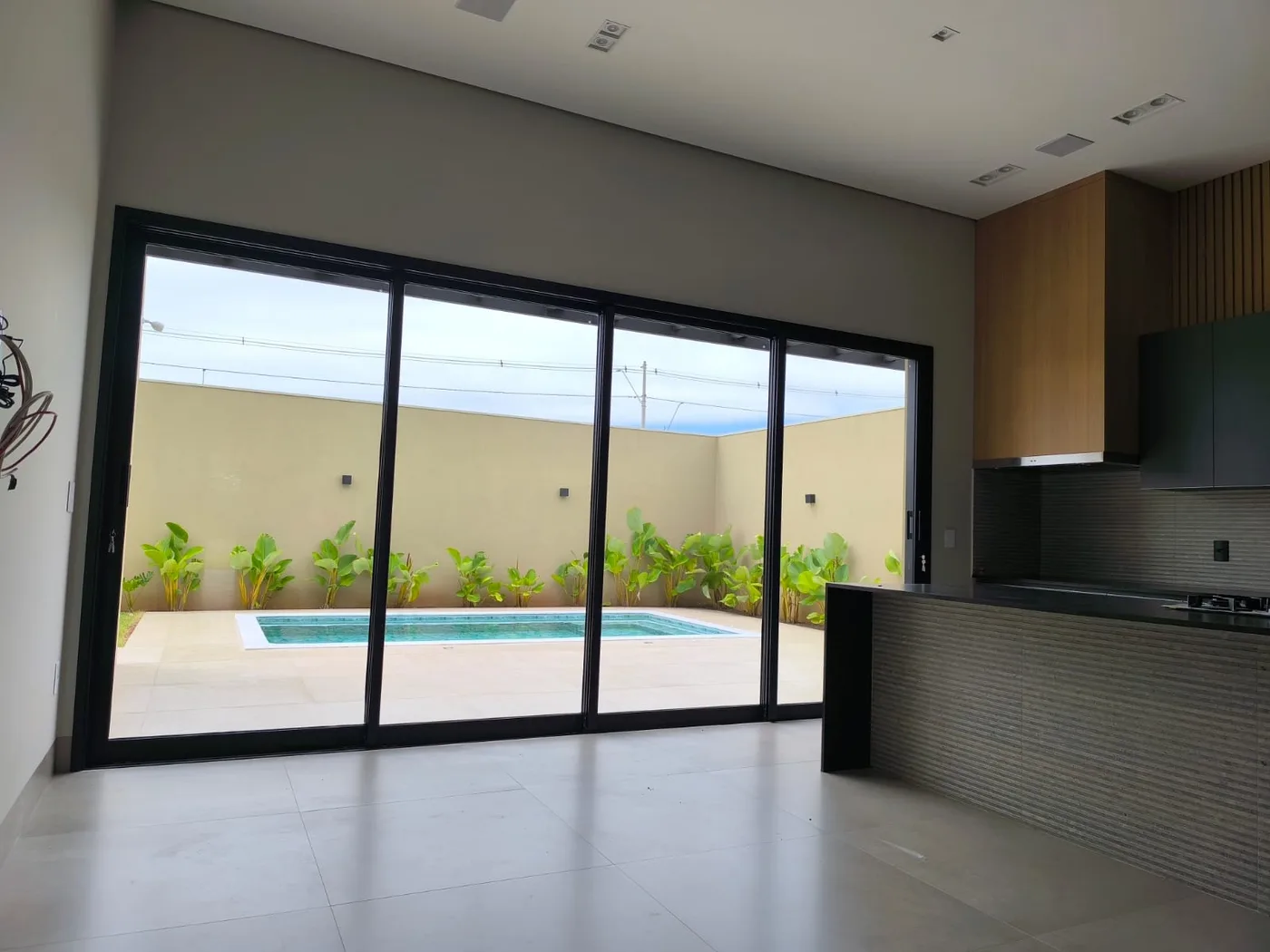 Grande esquadria de vidro integrando cozinha e área externa